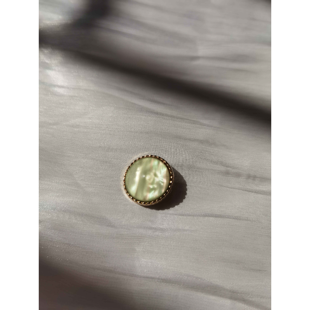 Flowing green metal button